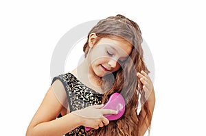 Little girl with long hair combing her hair