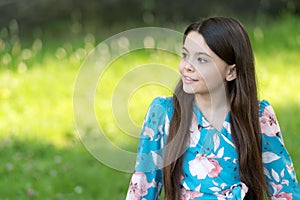 Little girl with long hair relaxing in park sunny day green grass background, dreaming big concept
