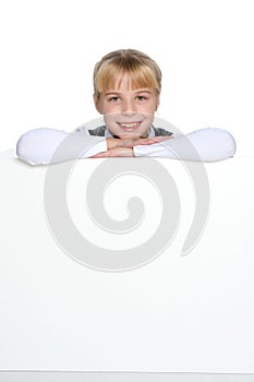 A little girl is looking from behind an empty banner.