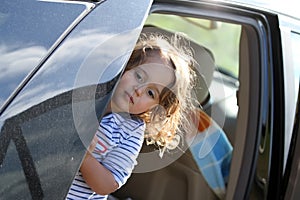 little girl looking from car