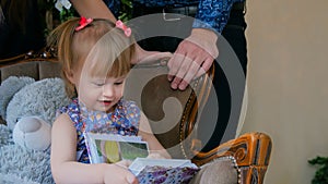 Little girl looking photobook at home