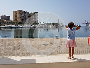 Little girl looking at the Port of Malaga photo