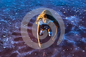 A little girl is looking at salt in a transparent water surface on a transparent background