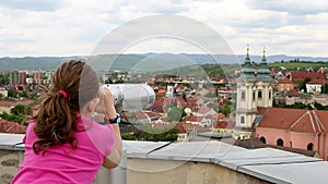 Little girl looking through sightseeing binoculars