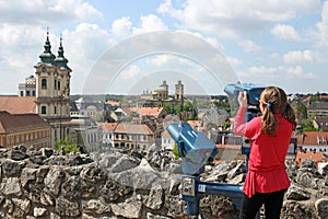 Little girl looking through sightseeing binoculars on Eger