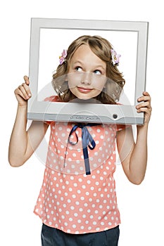 Little girl looking through the TV / computer screen frame