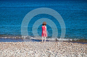 Little girl looking at waves