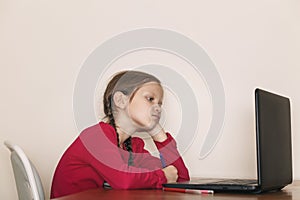 Little girl looks at the computer screen.