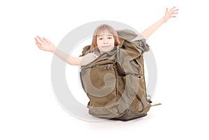 Little girl looks out of a large tourist backpack