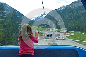 Little girl looks out the window of ski lift