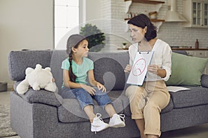 Little girl looks at a picture shown to her by a child psychologist at her reception.