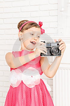 Little girl looks at retro camera