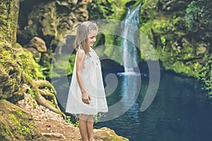 Little girl looks at the smiling water by a river photo