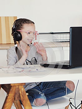 Little girl looks at tablet and learns lessons.