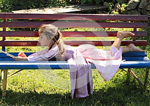 Little girl lying on bench