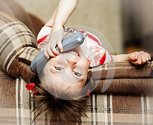 Little girl lying down talking on a wired phone