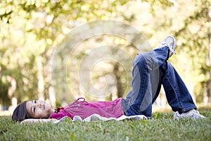 Little girl lying on grass