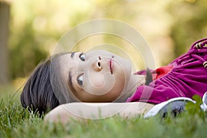 Little girl lying on grass
