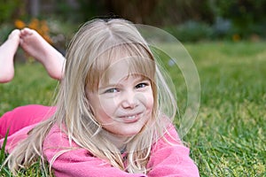 Little girl lying in grass