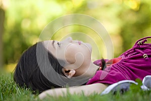 Little girl lying on grass