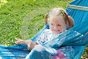 Little girl lying on hammock and smiling