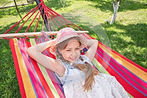 A little girl lying in a hammock on the street in the park