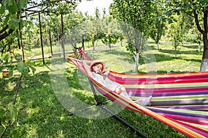 A little girl lying in a hammock on the street in the park