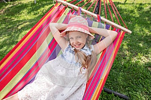 A little girl lying in a hammock on the street in the park