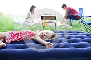 Little girl lying on an inflatable mattress