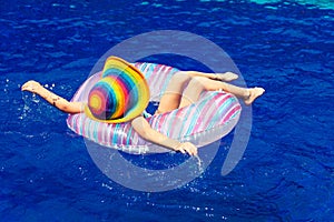 Little girl lying on the inflatable rubber circle in the swim