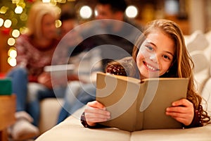 Little girl lying and reading children book for Christmas