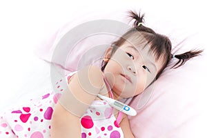 Little girl lying on sickbed with digital thermometer in her arm