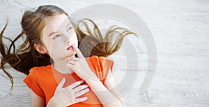 Little girl lying on white wooden floor