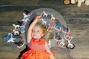 Little girl lying on the wooden floor and looking up,