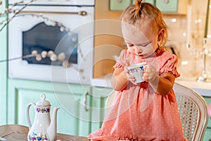 Little girl made Cup of tea with cake in kitchen.festive lunch.playing with kids