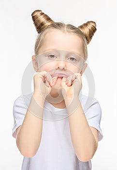 Little girl made a sad grimace on a white background. The concept of manifestation of discontent or whim photo