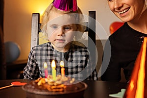 Little girl make a wish before blow out the candles on her birthday cake