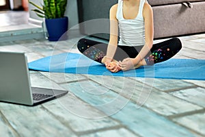 Little girl make workout on blue mat at home by laptop online