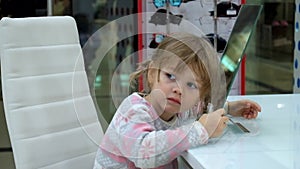 Little girl makes faces in front of a mirror