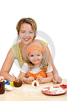 Little girl making cookies with her mother