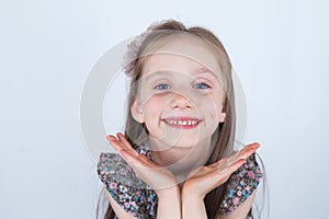 Little girl is making faces. Funny and happy expressions. Having fun. Preschooler in dress on white background.
