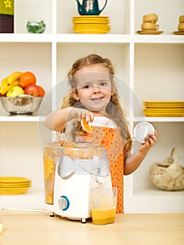 Little girl making fresh fruit juice