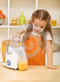Little girl making fresh fruit juice