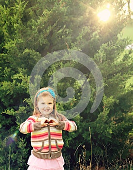 Little girl making heart symbol