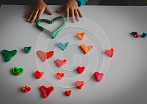 Little girl making hearts from clay, valentine day crafts