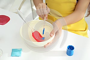 Little girl making homemade slime toy at table