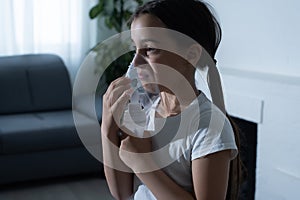 Little girl making inhalation with nebulizer at home. child asthma inhaler inhalation nebulizer steam sick cough concept