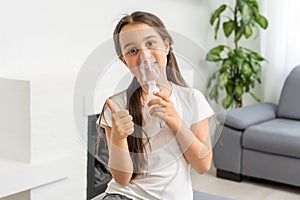 Little girl making inhalation with nebulizer at home. child asthma inhaler inhalation nebulizer steam sick cough concept