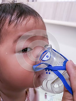 Little girl making inhalation with nebulizer at home. child asthma inhaler inhalation nebulizer steam sick cough concept