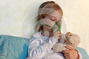 Little girl making inhalation with nebulizer home. Sick allergic kid asthma inhaler steam cough. Child allergy rhinitis